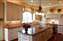 Layered lighting: multiple pools of light from island chandelier, pot lights and under - cabinet light